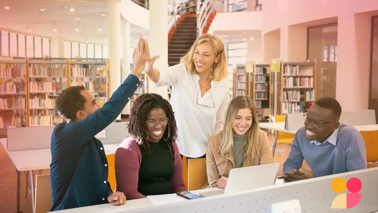 Equipe de colaboradores e uma gestora feliz em uma biblioteca moderna, trabalhando colaborativamente com laptops e smartphones